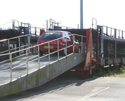 Cars are loaded onto the motorail train by SNCF (French Railways) staff...